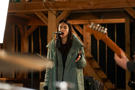 Girl singing into a microphone to record vocals