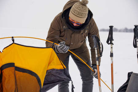 Two guys are setting up a tent in the snow. Setting up a tent during a winter expedition in extreme...