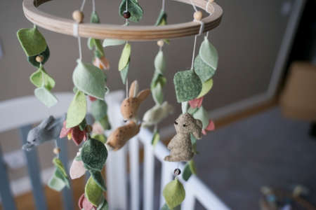 DIY craft baby crib mobile. Toys hang over the crib