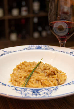 Risotto of funghi porcini with glass of wine.の写真素材