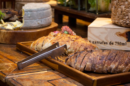 Homemade breads and assorted cheeses exposed on the wooden table.