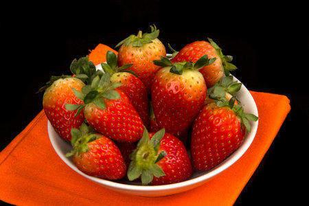 Red fresh strawberry in a bowl on black backgroundの写真素材