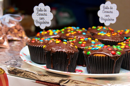 Cupcake varieties with decorative plate with the phrase Carrot cake with brigadier on the wooden...