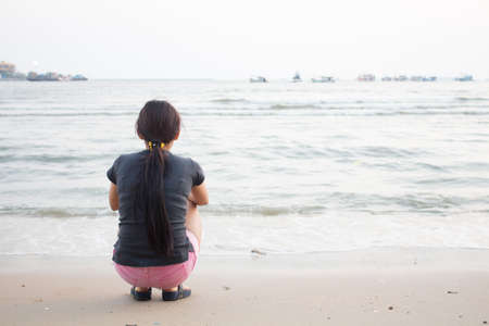 Woman and sea evening In an atmosphere of loneliness and solitaryの写真素材