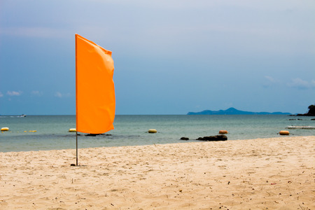The orange flag on beach, sea backgroundの写真素材