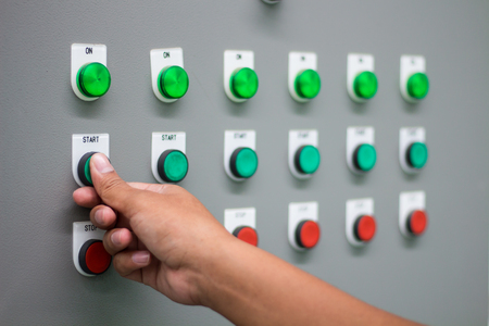 The hand pressing "start" switch on control boardの写真素材