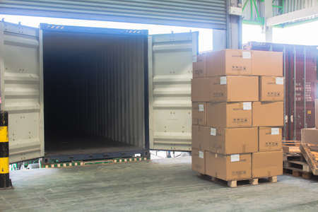 loading shipment carton boxes and goods on wooden pallet at loading dock from containerの写真素材