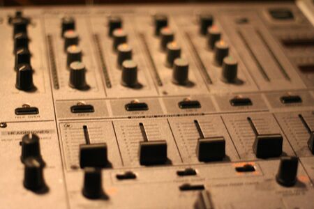 a close up of a deejay console with mixers in the middle
