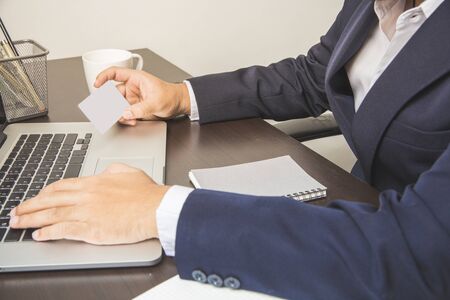 Asian business man holding card for complete credit id in laptop past internet buy product to sale in store companyの写真素材