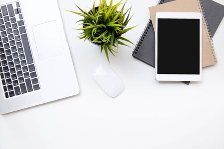 office desk table work space top overhead place layout left laptop keyboard center plant with mouse for use right laptop isolated on notebookの写真素材