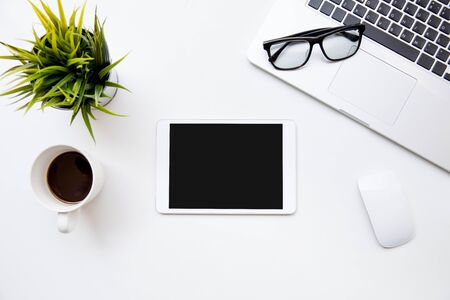Desk table top overhead space design layout place show tablet isolated for insert eveything screen at right have glasses on laptop keyboard near mouse useの写真素材