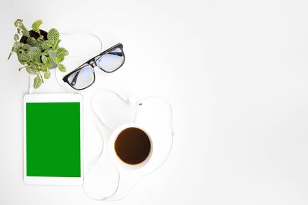 Work space office desk table top header layout side left relax break work in company drinking coffee cup play tablet listen music by earphone green screenの写真素材