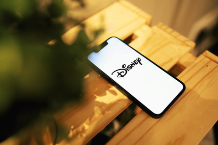 October 6, 2022: Disney logo on smartphone screen. Smartphone on tableのeditorial素材