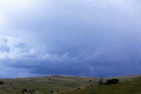 Severe thunderstorm in the countryside, changing the landscape from daylight to dark stormy clouds.の写真素材