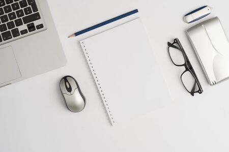 Office desk or educational desk with laptop, white sheet book, glasses to see, external hard drive,...