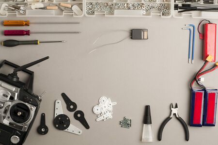 Workshop table drone composition, (center clearance), with radio control aero model (RC) control, drone parts, and tools on the gray worktable. Top viewの写真素材
