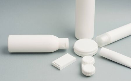 Collection of various beauty hygiene containers on soft gray background. Space to fill