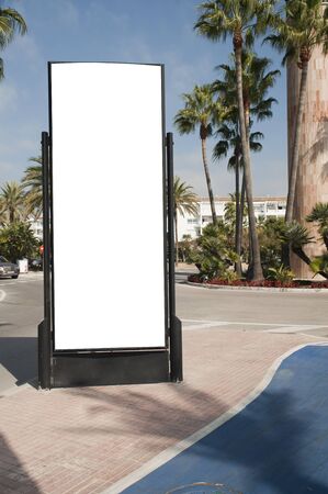 Billboard, banner, empty, white in the city center with street with palm trees, green plants and bicycle laneの写真素材
