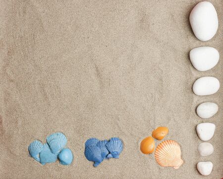 sets of 3-color cochas, blue, light blue, orange and white stones on beach sandの写真素材