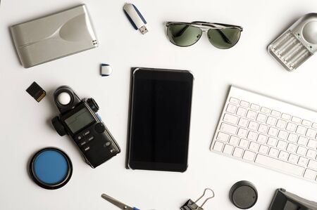 Flat assembly composition with photographic production equipment on plain white background, top view