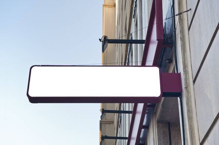 Blank mockup of burgundy signboard store on a yellow wall, blue skyの写真素材