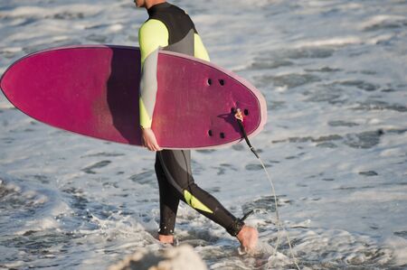 surfer on the beach shore, surfboard, with sea in the backgroundsurfer on the beach shore, surfboard, with sea in the backgroundの写真素材