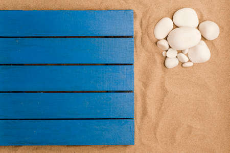 summer in the beach concept, blue wooden flooring on beach sand, white stones on beach sand.top view. space for textの写真素材