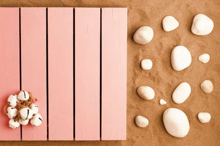 summer in the beach concept, pink wooden platform on beach sand with shells and white stones. beach sand background.top viewの写真素材