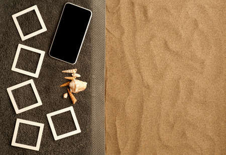 Concept photo beach memories collage photo frames mockup on gray towel, smart phone with black screen, shells. fine beach sand. Top view, space for texの写真素材