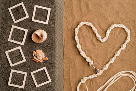 concept photo beach memories collage photo frames mockup on gray towel with shells. beach sand with nautical lines heart shape. Top view. space for textconcept photo beach memories collage photo frameの写真素材
