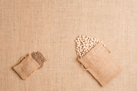 Texture or background of brown sackcloth with linen bags with lentils and chick peas. Top viewの写真素材