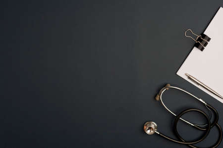 Medicine accessory, stethoscope with notepad, black background with copy space. top viewの写真素材