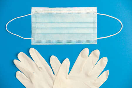 Covid-19 concept, protection and hygiene, surgical mask and gloves, blue background. Top viewの写真素材