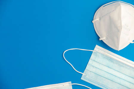 covid-19 concept, partial view of different types virus protection masks with blue background, space for text. top viewの写真素材
