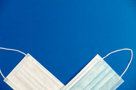 covid-19 concept, partial view of virus protection surgical masks with blue background, space for text. top viewの写真素材