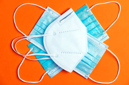 covid-19 concept, different types virus protection masks with orange background, space for text. top viewの写真素材