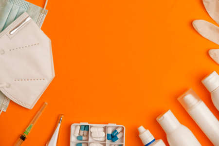 Covid-19 (coronavirus) concept with medical instruments and protective material, orange background,...