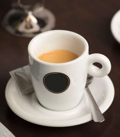 close-up detail cup of freshly brewed hot coffee, on top of the wooden table, inside the cafe and free space for decorationの写真素材