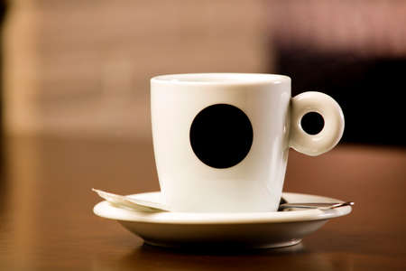 cup of freshly brewed hot coffee, on top of the wooden table, inside the cafeteria and free space for decoration.の写真素材