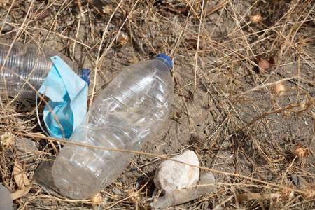 Discarded to single-use virus face masks. Pollution of the environment, with plastics in the field