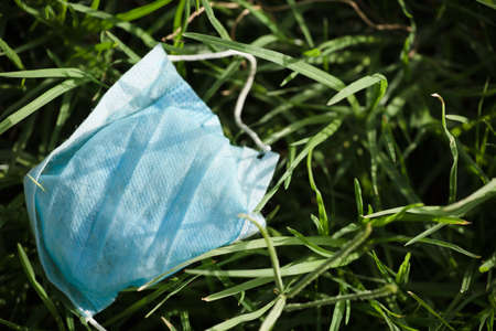 Waste during COVID-19. Discarded to single-use coronavirus face masks. Environmental pollution, on...