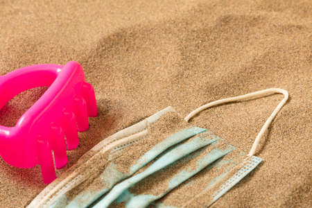 fuchsia little boy toy rake with Waste during COVID-19. Discarded to single-use coronavirus face...