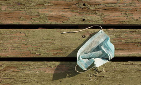 Waste during COVID-19. Dumped into coronavirus single-use face masks. Environmental plastic...