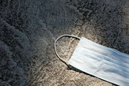 Medical protection mask lost on the ground was used. Disposable mask lying on the street....