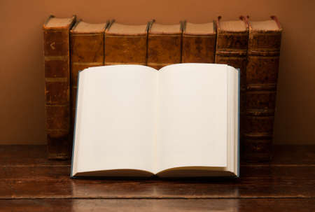old books on wooden desk, with open book