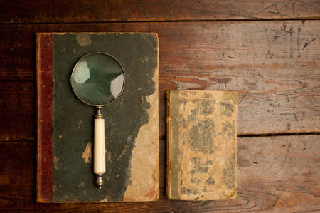 bretro old books with optical magnifying glass on old wooden table