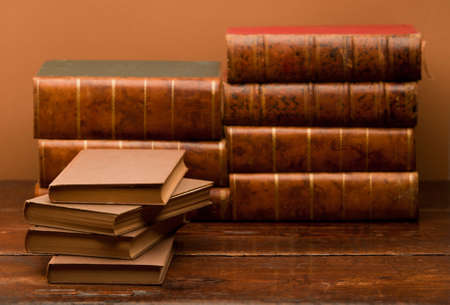 stack of old books on wooden table with brown backgroundの写真素材