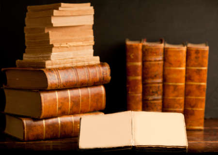 old books on wooden desk, with open book
