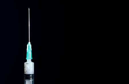 Closed syringe isolated on black background