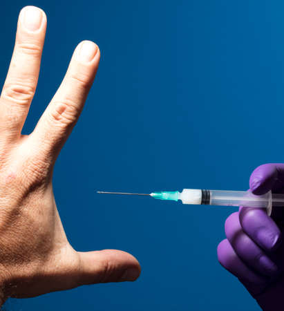 Man showing his palm refusing nurse injection or vaccination.の写真素材